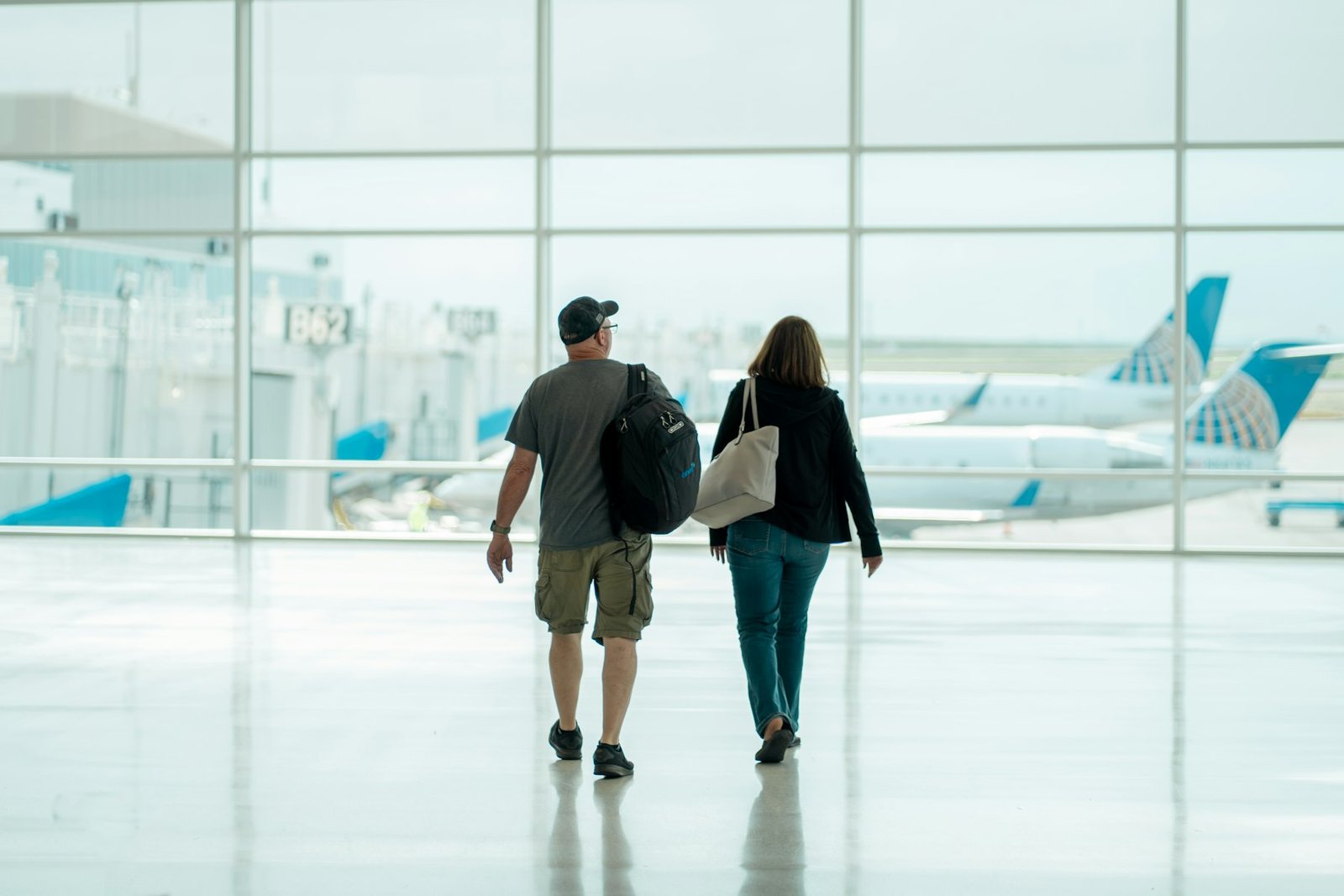 Dos personas caminando con su equipaje por una terminal de aeropuerto